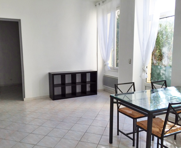 Appartement Kennedy 1 salon carrelage blanc et vue sur jardin résidence les cyprès vignette